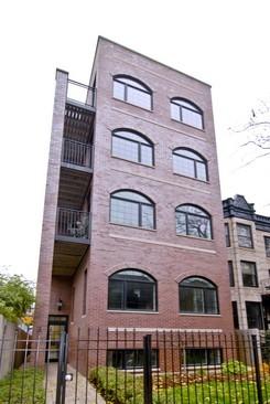 Front view of a multi-story brick building with arched windows.