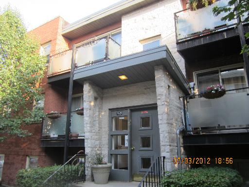 Front view of a multi-story building with balconies and a central entrance.