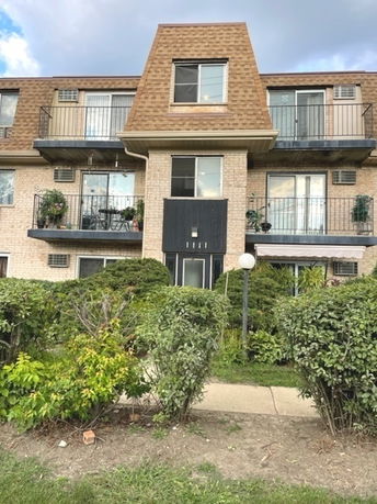 Front view of a three-story apartment building with balconies.
