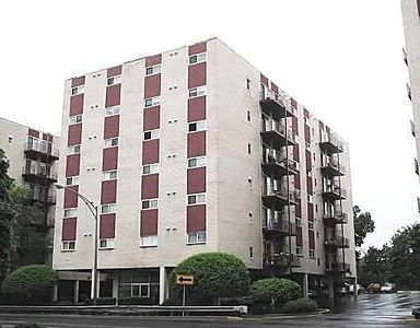 Front view of a multi-story residential building with balconies.