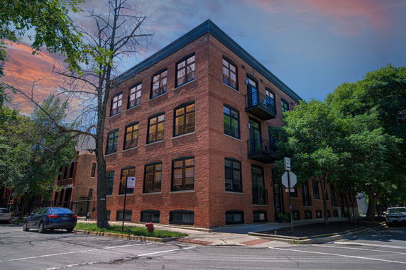 Front view of a three-story brick building on a corner lot.