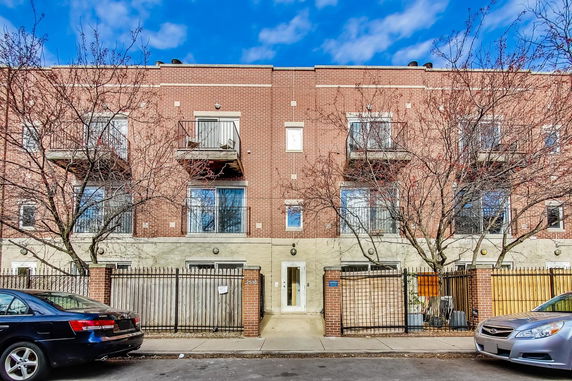 Front view of a multi-story brick building with balconies.