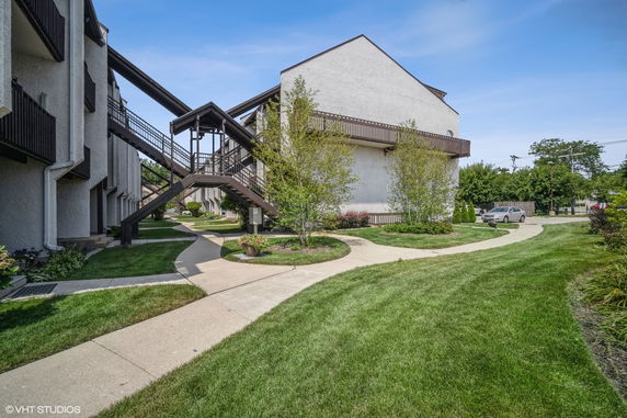 Front view of a residential building with walkways and green landscaping.