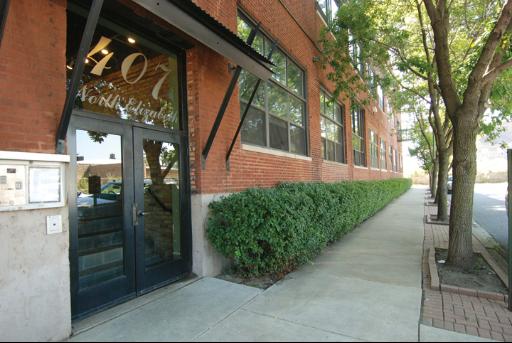 Front view of a brick building with large windows and a glass entrance door.