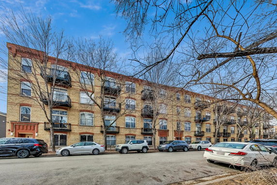 Front view of a four-story apartment building with balconies.