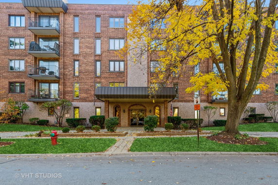Front view of a multi-story brick building with balconies.