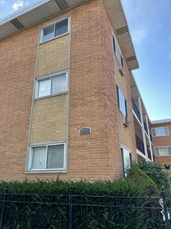Front view of a brick, multi-story apartment building.