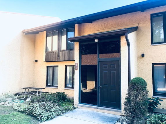 Front view of a two-story house with a central door and multiple windows.