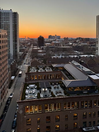 Panoramic view of a cityscape at sunset with buildings visible.