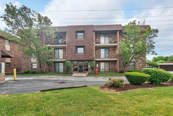 Front view of a three-story brick apartment building.
