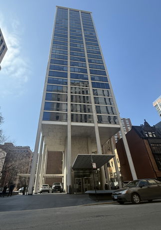 Front view of a tall, modern glass and concrete building.