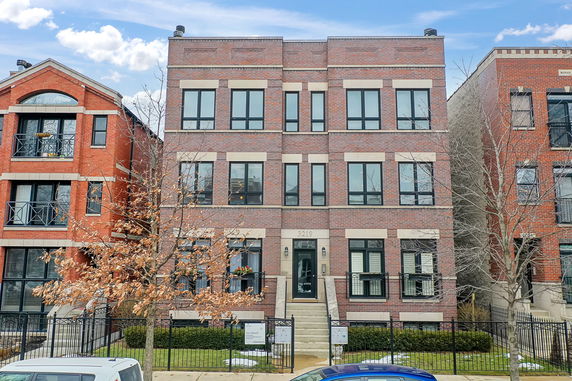 Front view of a three-story brick building with multiple windows and a central entrance.