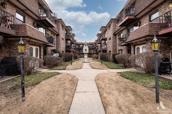 Front view of a brick residential building with multiple levels and balconies.