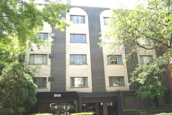 Front view of a multi-story building with a black and cream facade.