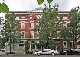 Front view of a multi-story brick building with large windows.