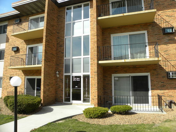 Front view of a brick apartment building with balconies.