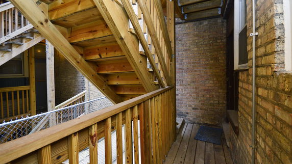 Exterior view of a building with wooden stairs and railing