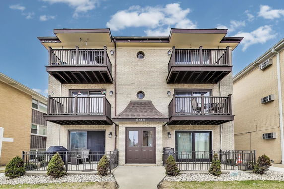 Front view of a three-story apartment building with balconies.