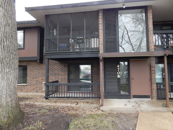 Front view of a two-story brick residential building with a balcony.
