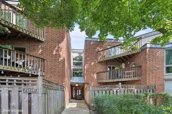 Front view of a brick apartment building with multiple balconies.