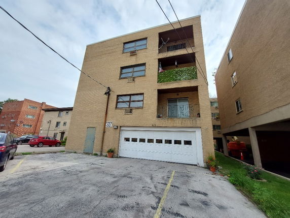 Front view of a multi-story building with a double garage.