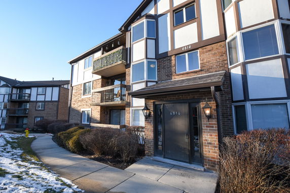 Front view of a multi-story apartment building with balconies.