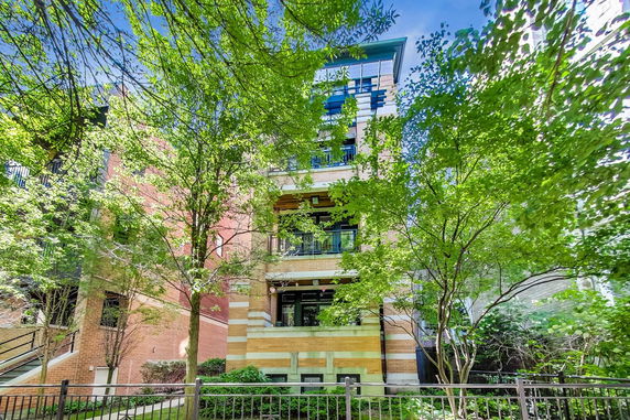 Front view of a multi-story residential building with balconies and a brick facade.