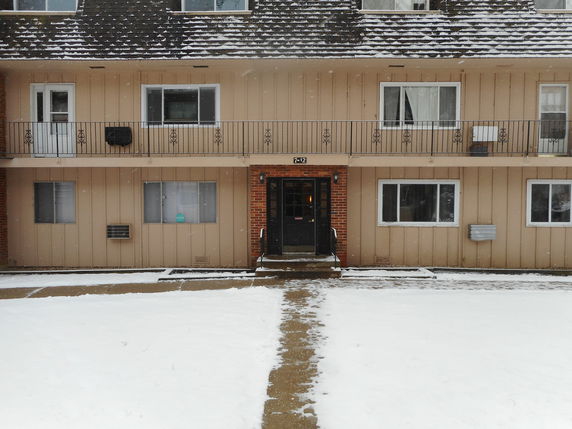 Front view of a two-story building with snow-covered ground.