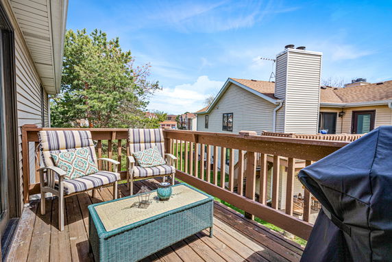 View from a balcony showing neighboring houses and a clear sky.