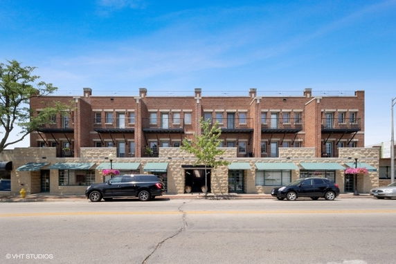 Front view of a multi-story brick building with balconies.
