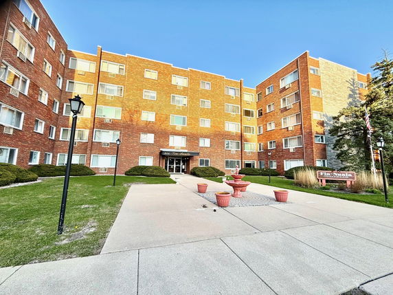 Front view of a multi-story brick building with multiple windows.