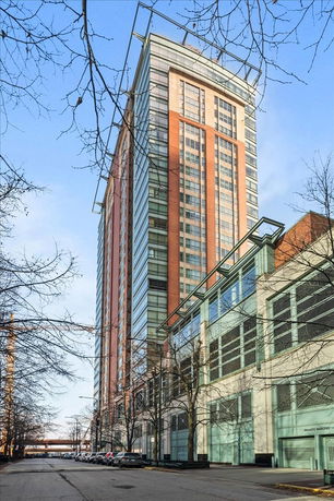 Front view of a high-rise building with a combination of brick and glass facade.