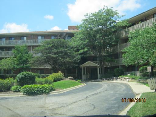 Front view of a multi-story residential building with balconies and entrance.