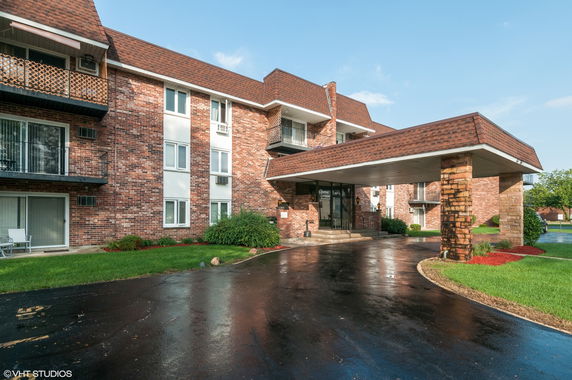 Front view of a multi-story brick building with a covered entrance.