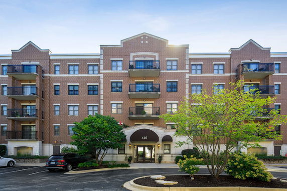 Front view of a multi-story brick apartment building with balconies.