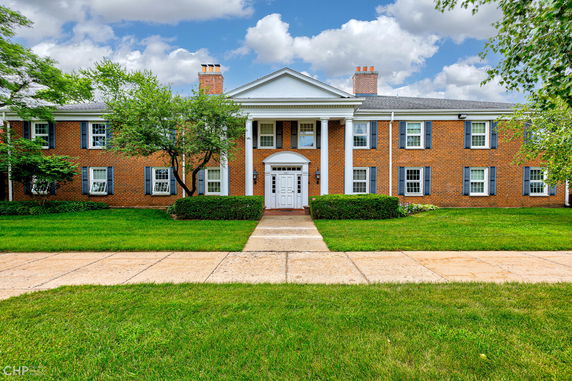 Front view of a two-story brick building with white columns.