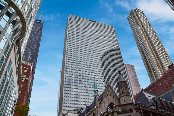 Urban skyline featuring several tall buildings and a historic structure.