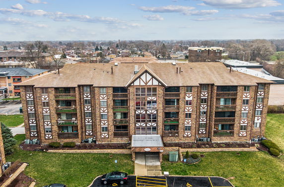 Front view of a multi-story apartment building with decorative brickwork and balconies.