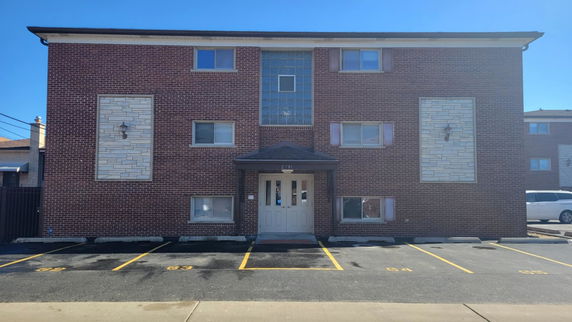 Front view of a three-story brick building with a central entrance.