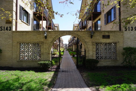 Front view of a multi-story apartment building with an arched entrance.