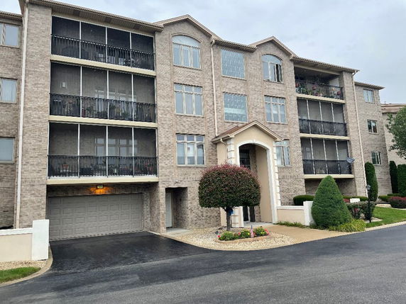 Front view of a multi-story apartment building with balconies.