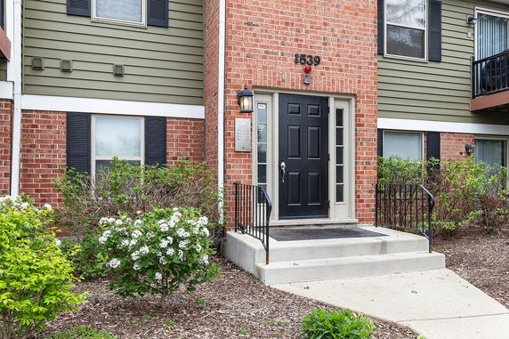 Front view of a house with a black door and brick facade.