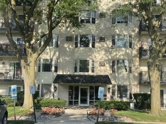 Front view of a multi-story apartment building with balconies.