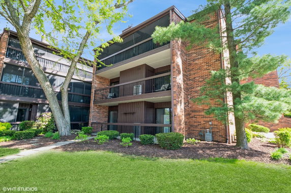 Front view of a multi-story building with balconies and brick exterior.