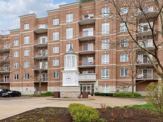 Front view of a multi-story brick building with balconies.