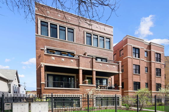 Front view of a multi-story brick building with balconies.