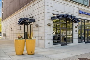 Front view of a building entrance with large yellow planters.