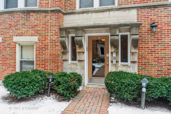 Front view of a brick building entrance with a glass door.