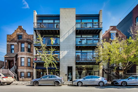 Front view of a multi-story residential building with balconies.