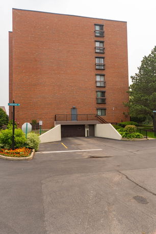 Front view of a multi-story brick building with parking area.